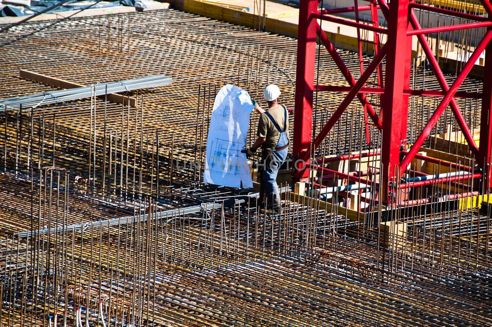 Detail with construction engineer and plan on site with steel and crane