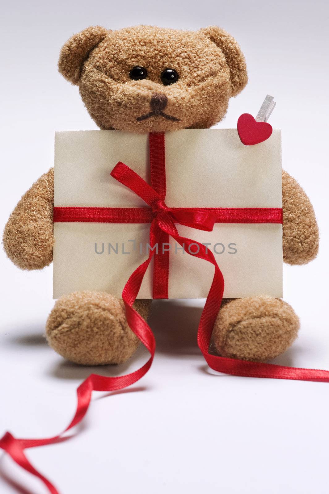 valentines day teddy bear holding envelope with decorative red ribbon