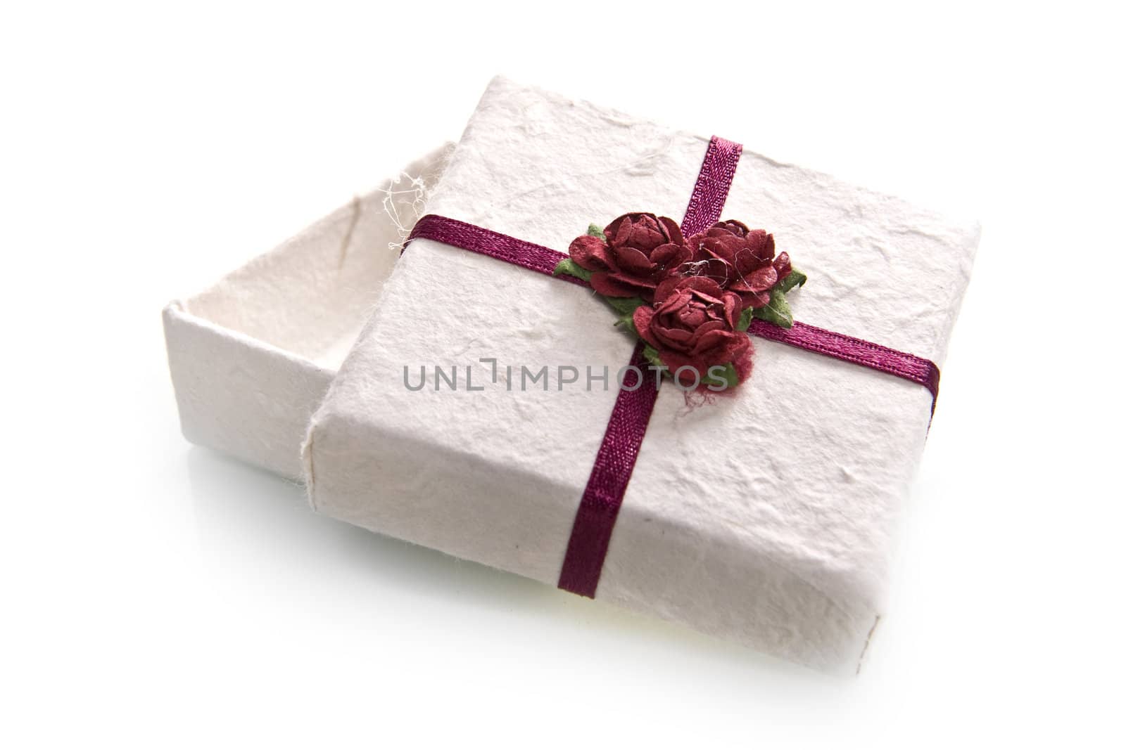 a white box with a bow and three tiny roses