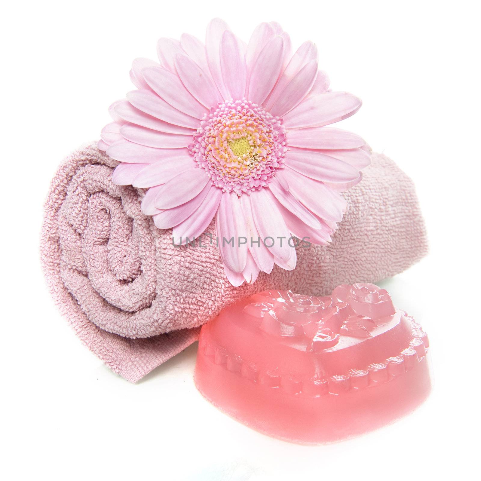 a towel, soap and a flower