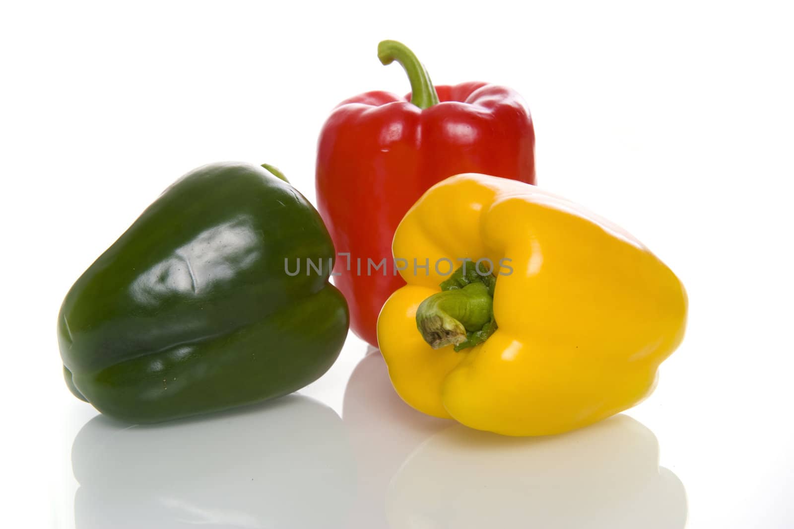 three healthy paprikas on a white background