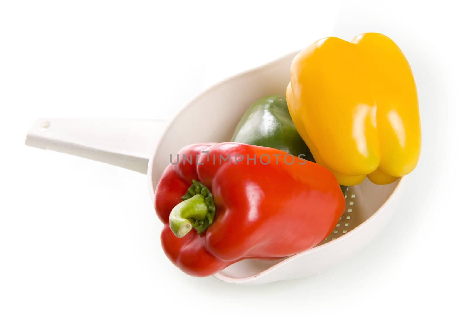 a colander with fresh and healthy paprikas on a white background