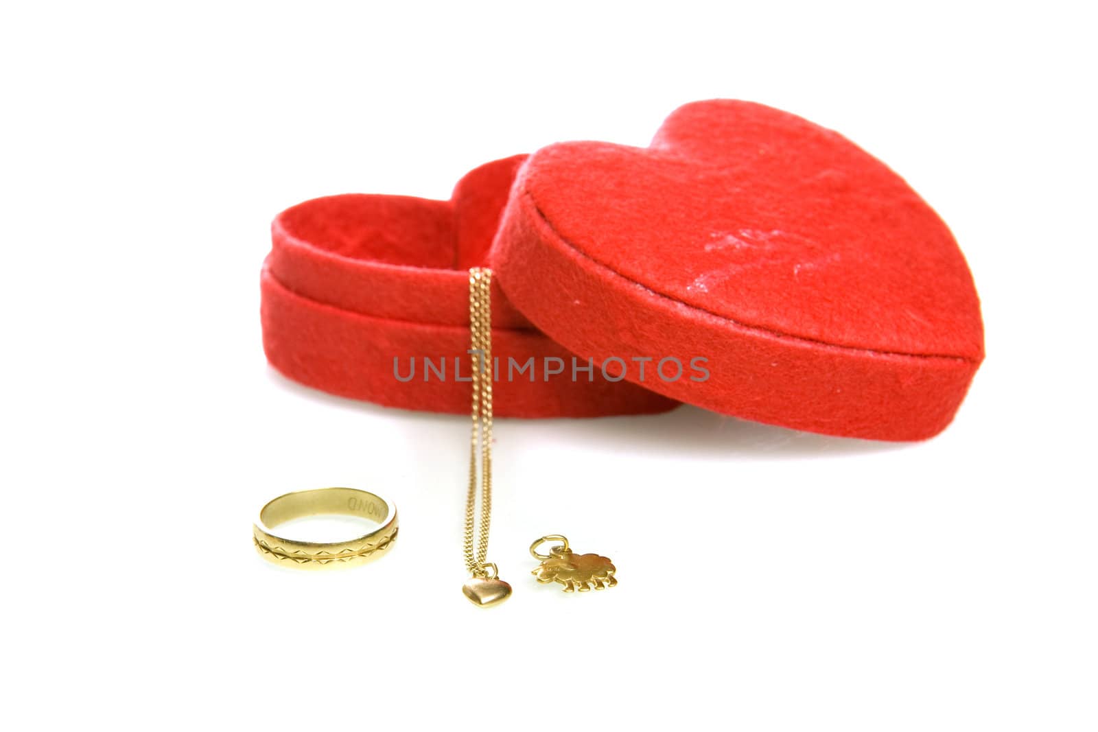 a red heart box with a golden chain and ring on a white background