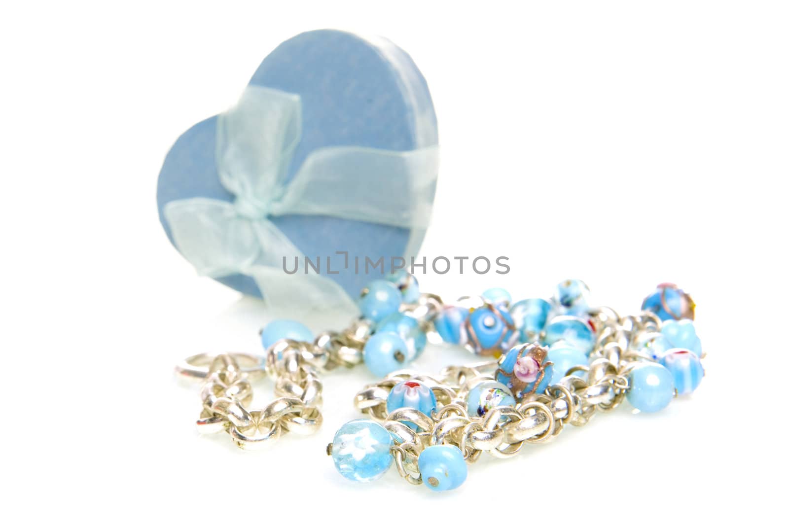 a blue heart box with jewellery on a white background