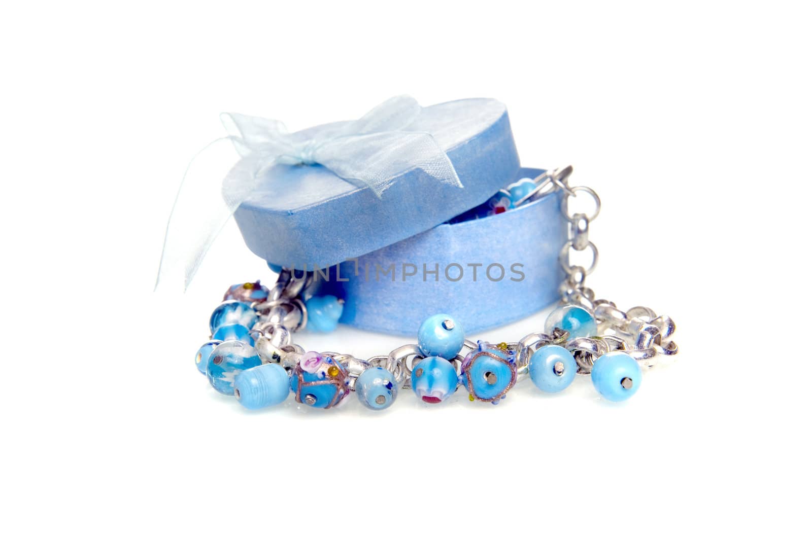 a blue heart box with jewellery on a white background