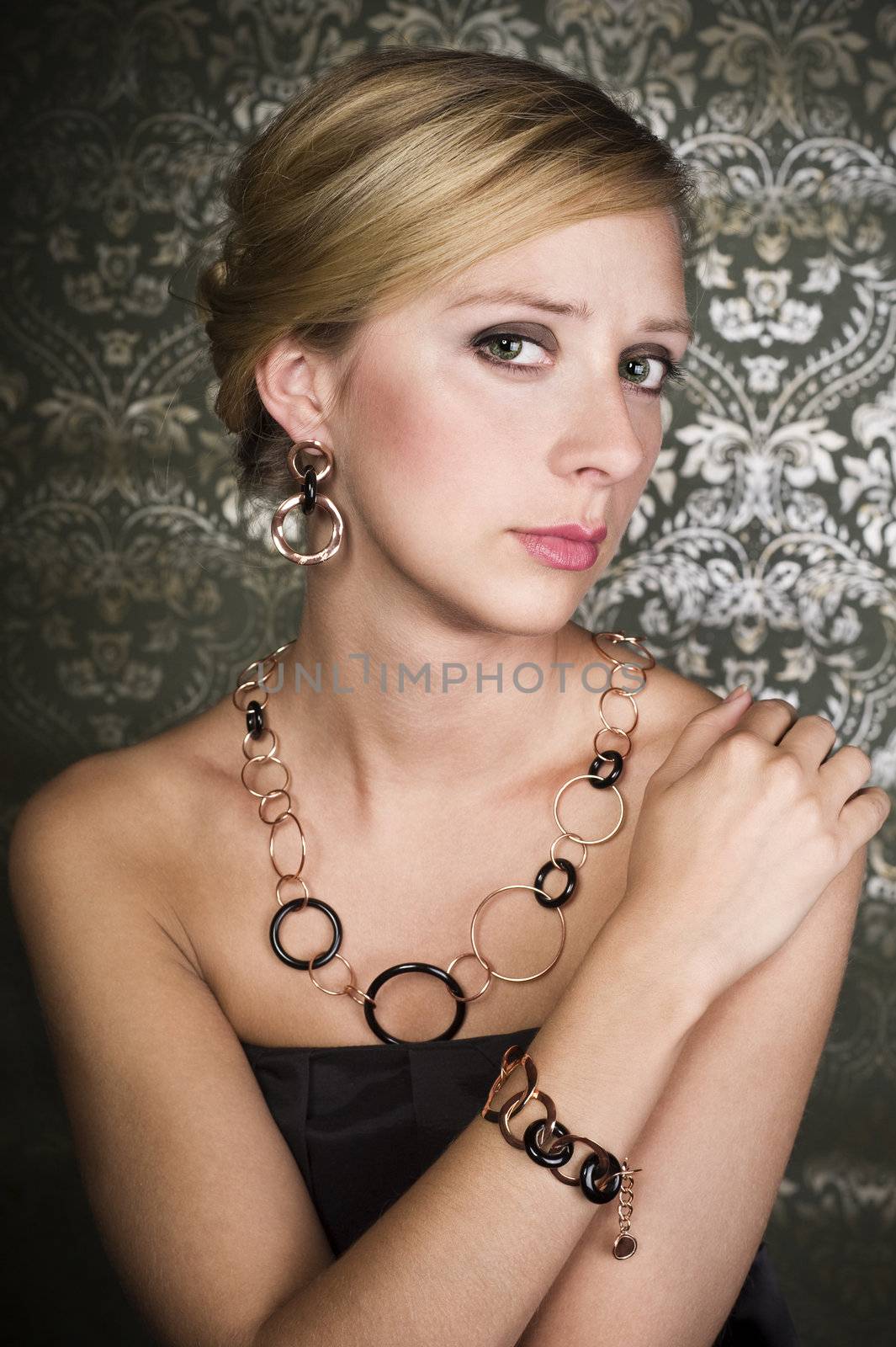 elegant woman wearing golden necklace and earring, over wallpaper background