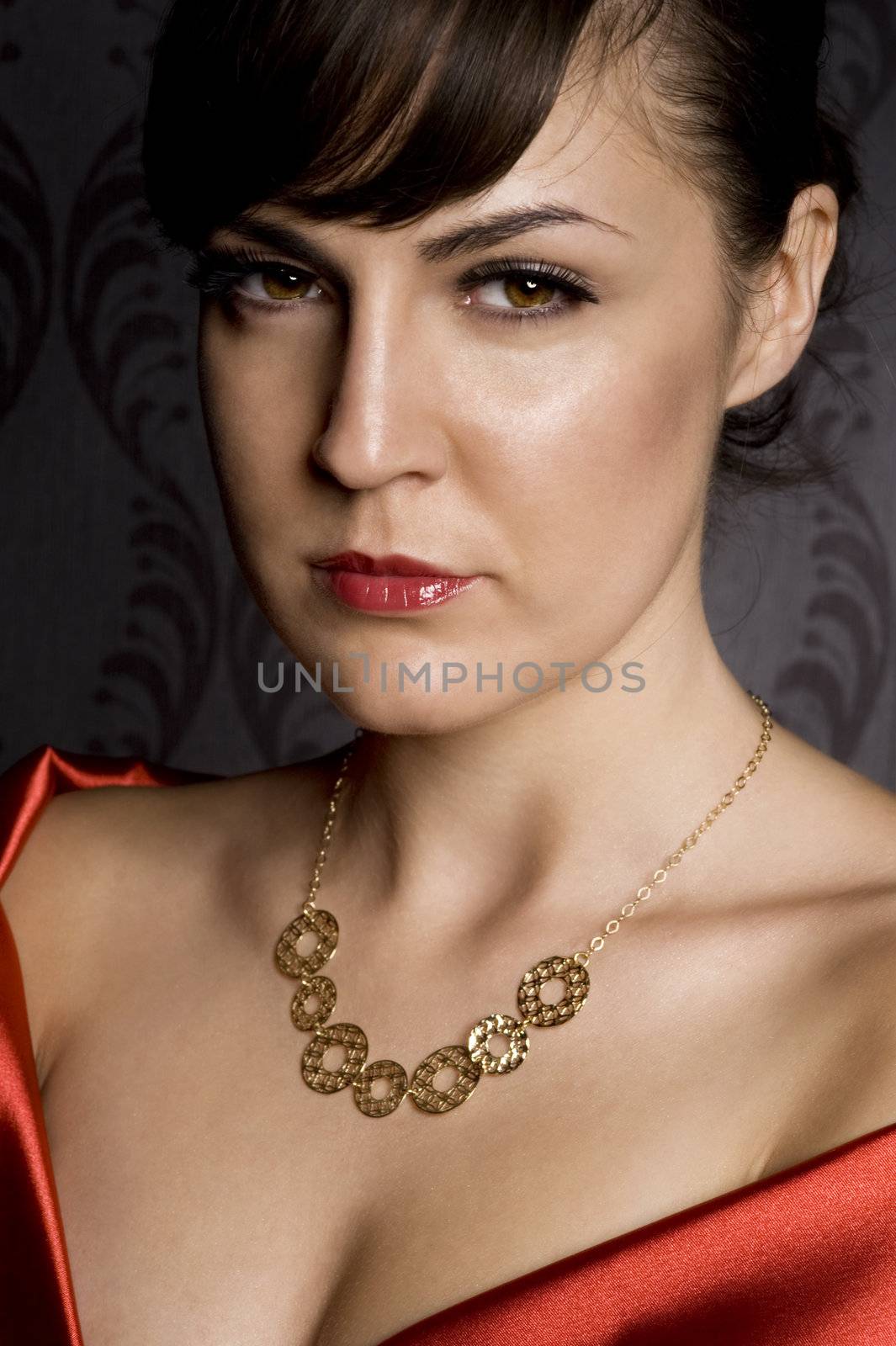 attractive woman wearing golden necklace over wallpaper background
