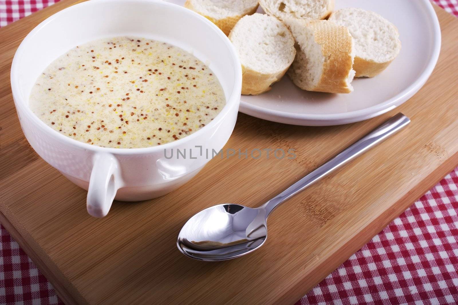 Traditional Dutch mustard soup on cutting board with spoon.