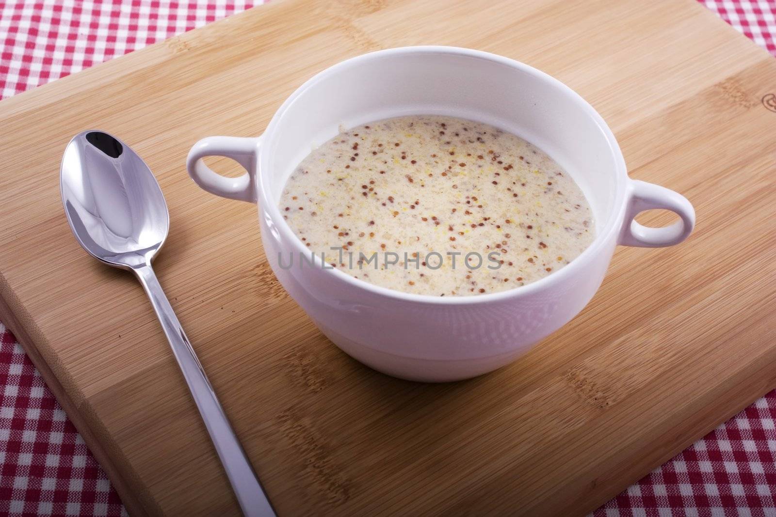 Traditional Dutch mustard soup on cutting board with spoon.