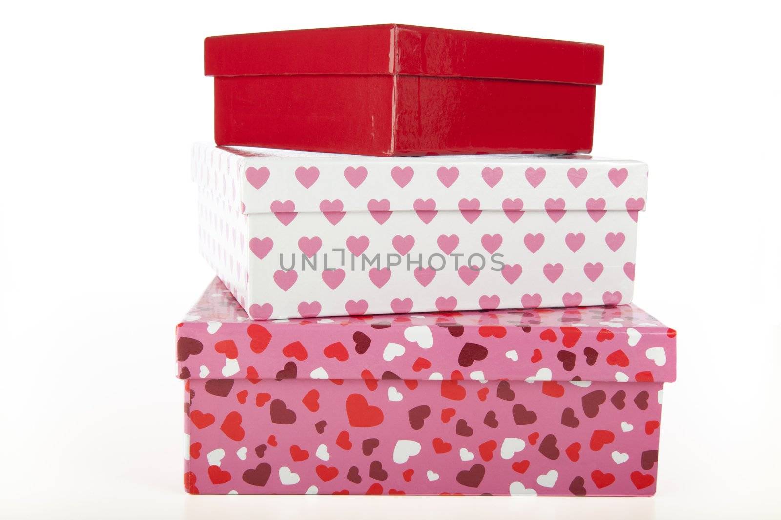 Three gift boxes with hearts and valentines colors on white background.