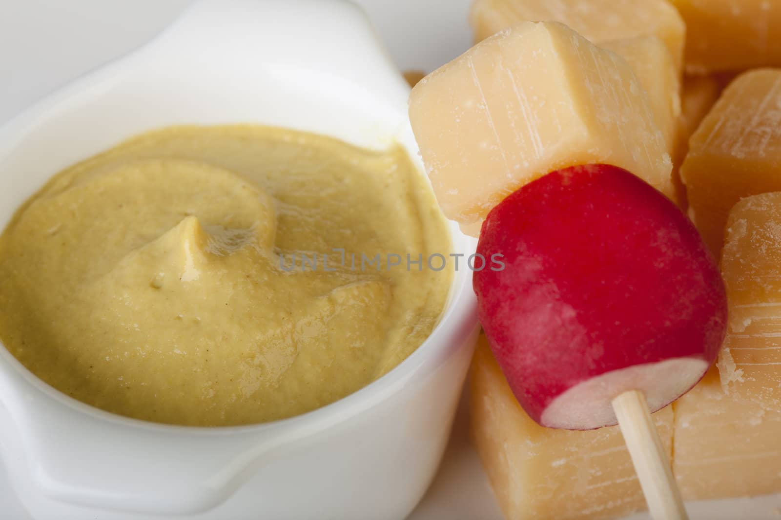 Appetizer of Dutch cheese cube and radish with mustard dipping sauce.