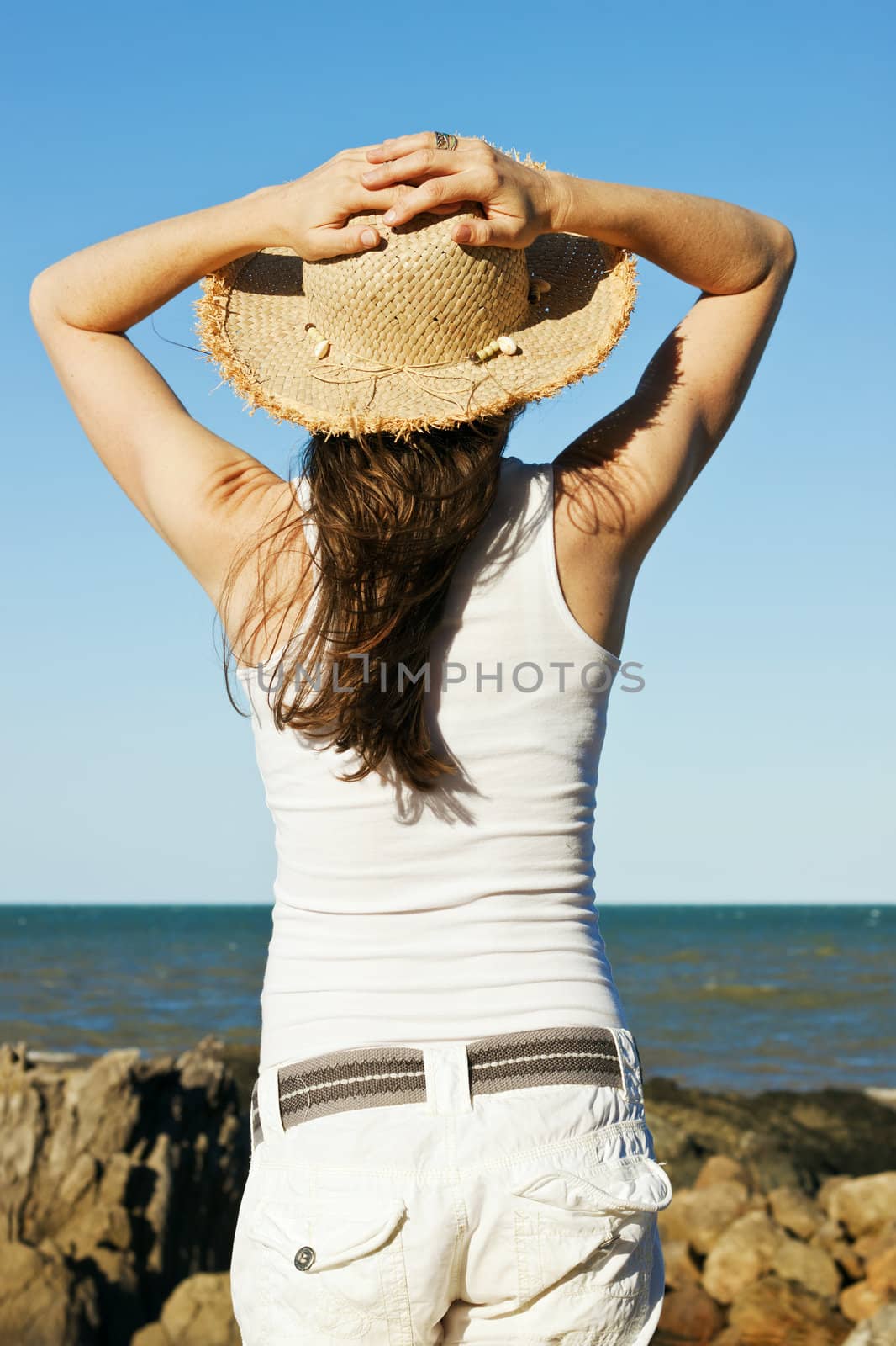 Beautiful young woman relaxing by the ocean