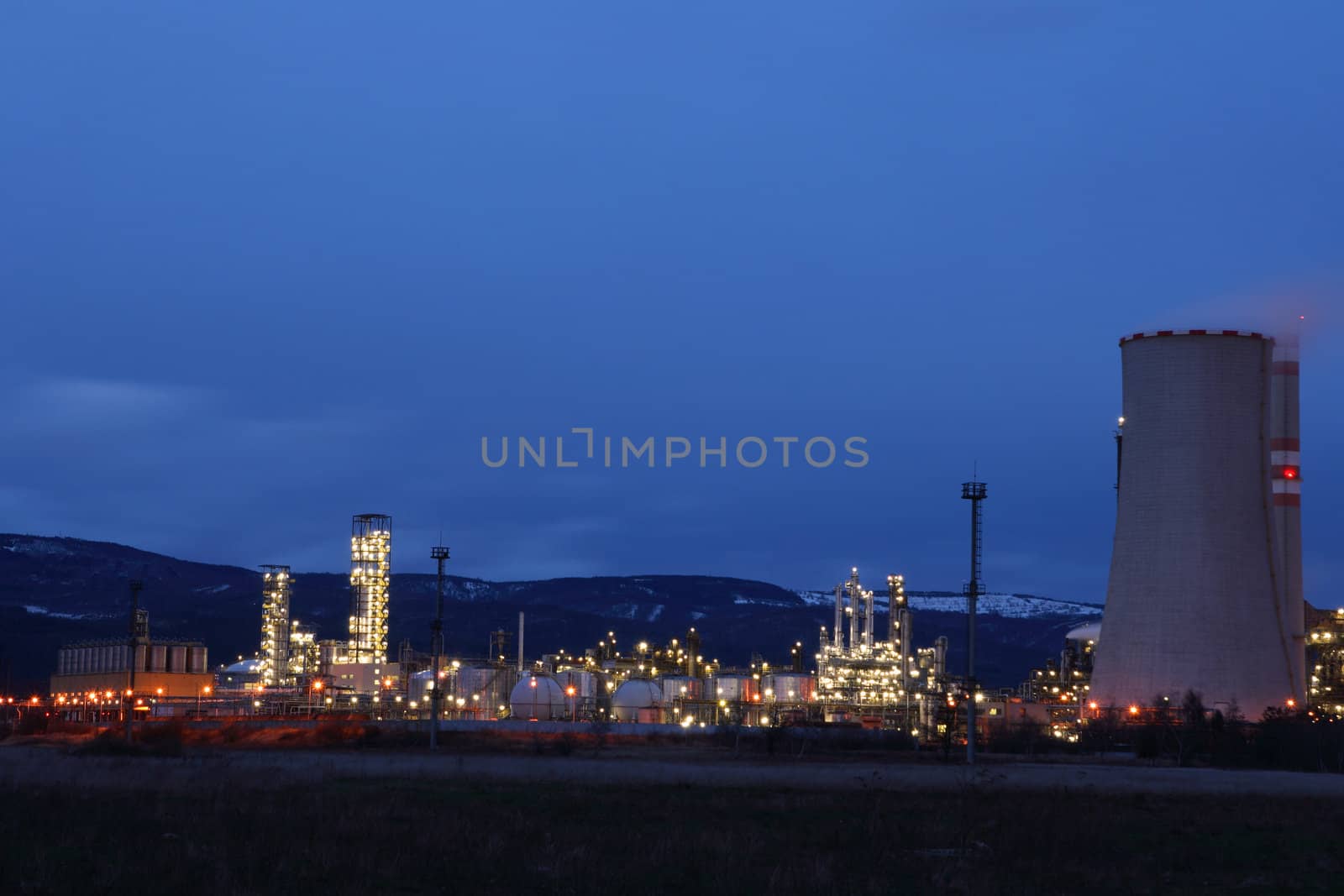 View of large petrochemical factory in early night light with shining lights