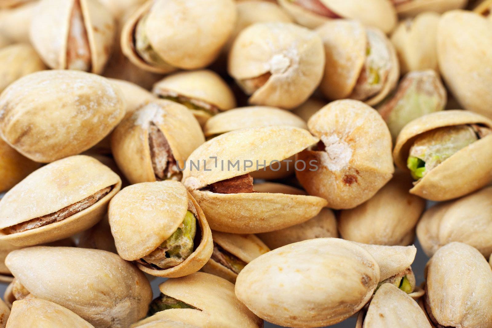 Closeup of roasted pistachio nuts by Jaykayl