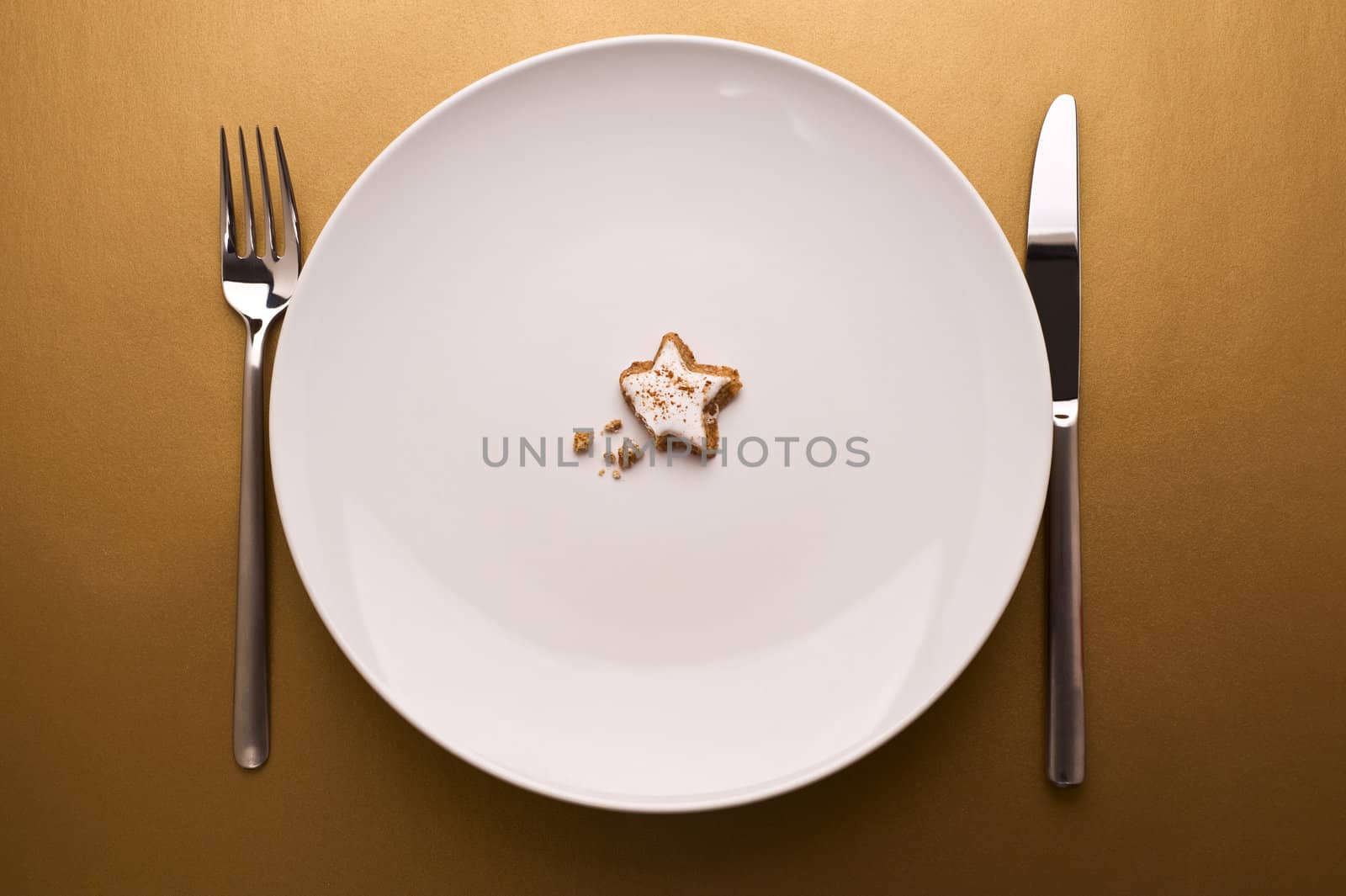 glazed nut cookie on dish on gold background