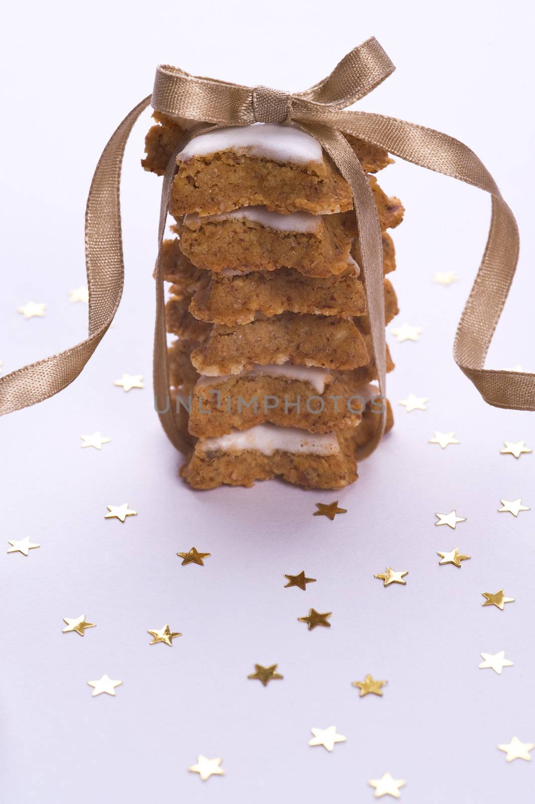 cookies with decorative gold ribbon and stars on white background
