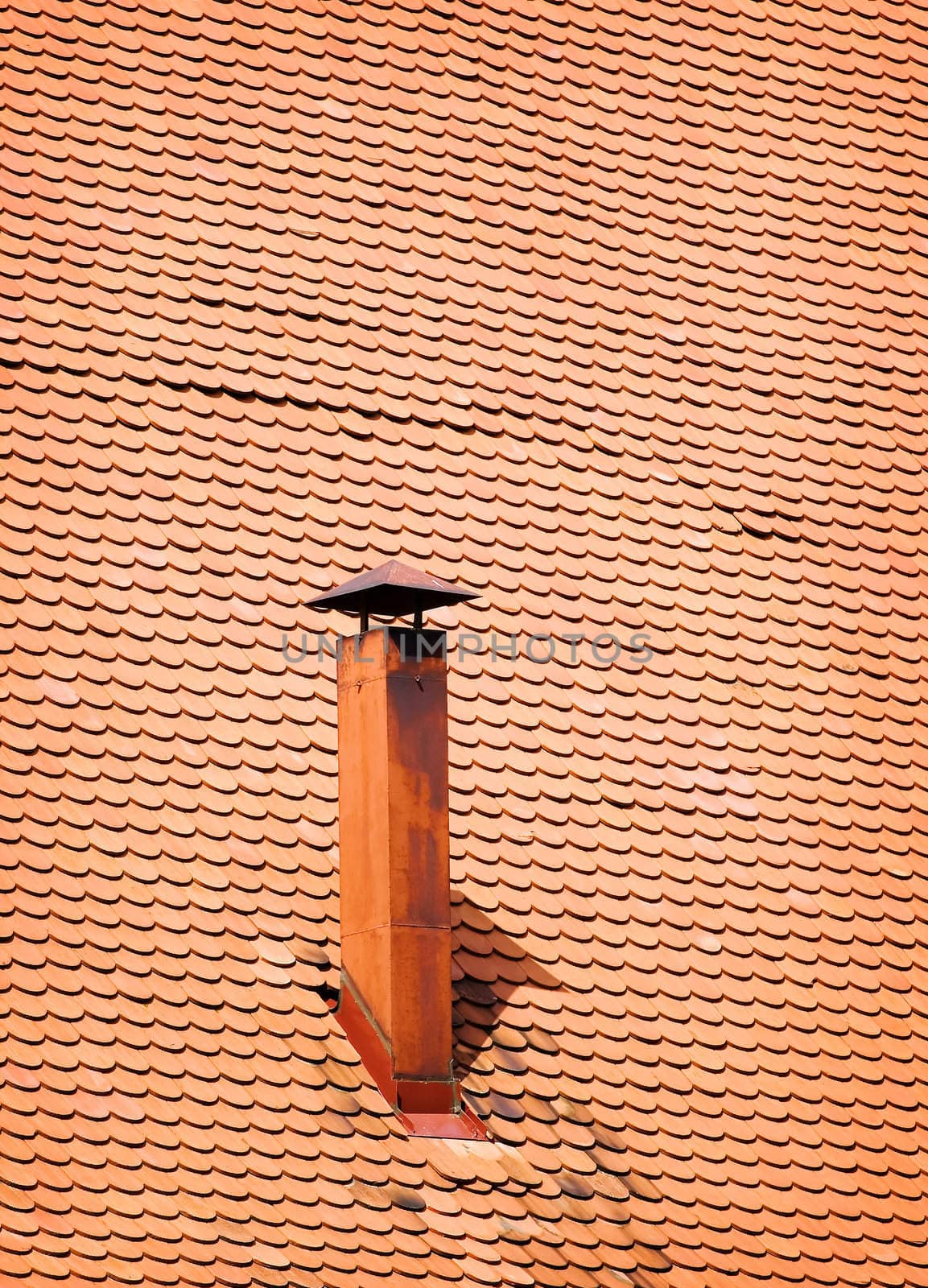 Diagonal perspective of a old roof with metal chimney