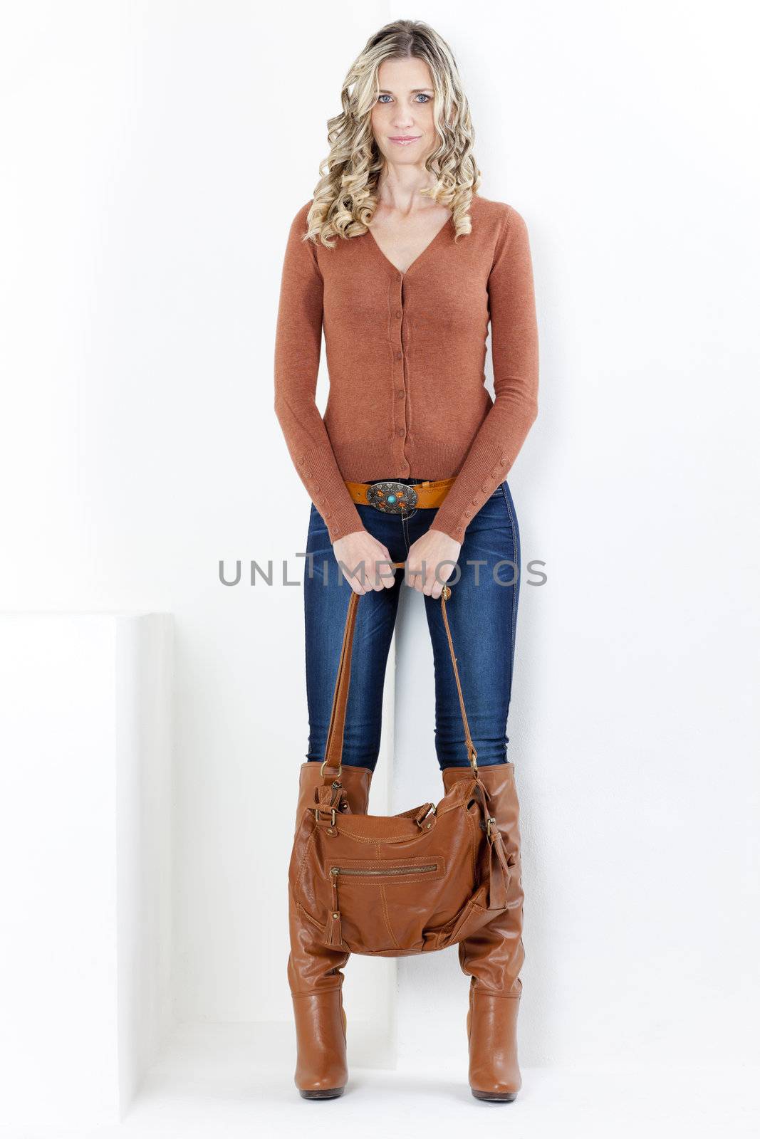 standing woman wearing fashionable brown boots with a handbag by phbcz