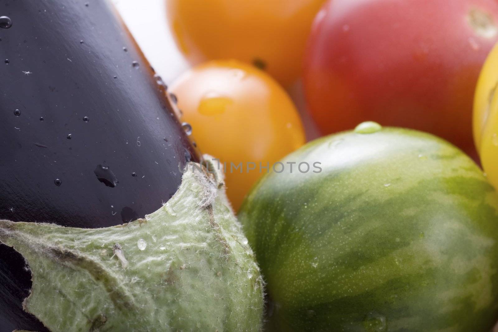 Close up of eggplant and colorful cherry tomatoes.  