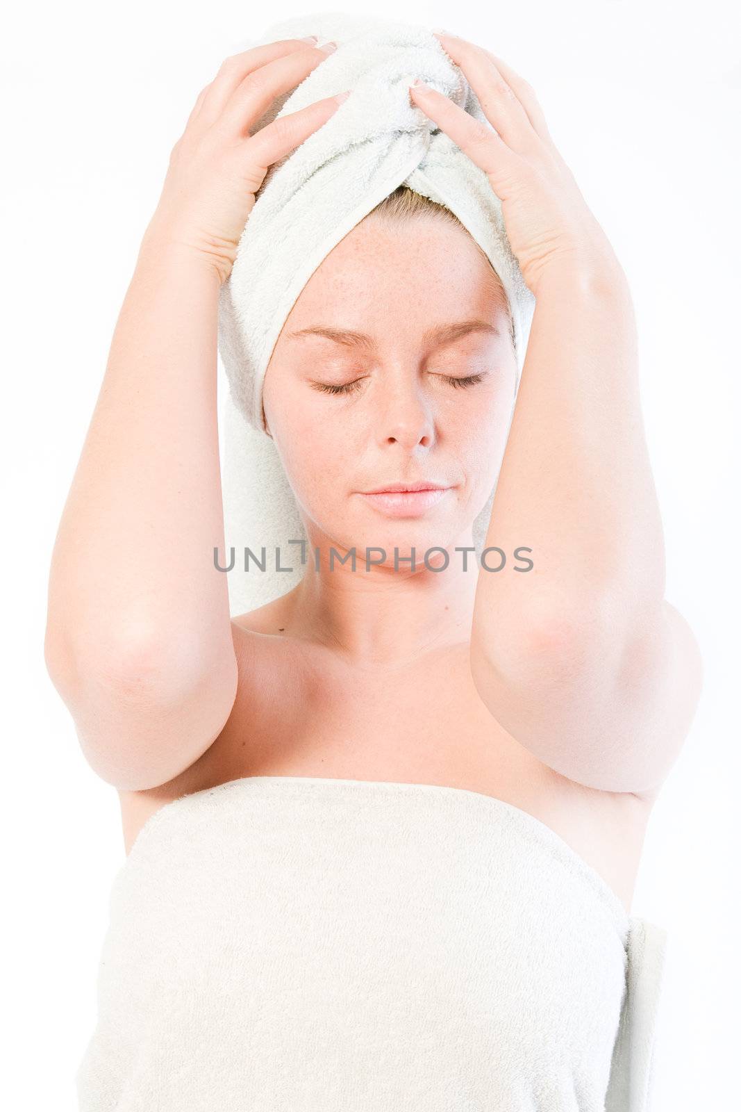 Studio portrait of a spa girl holding her towel on her head