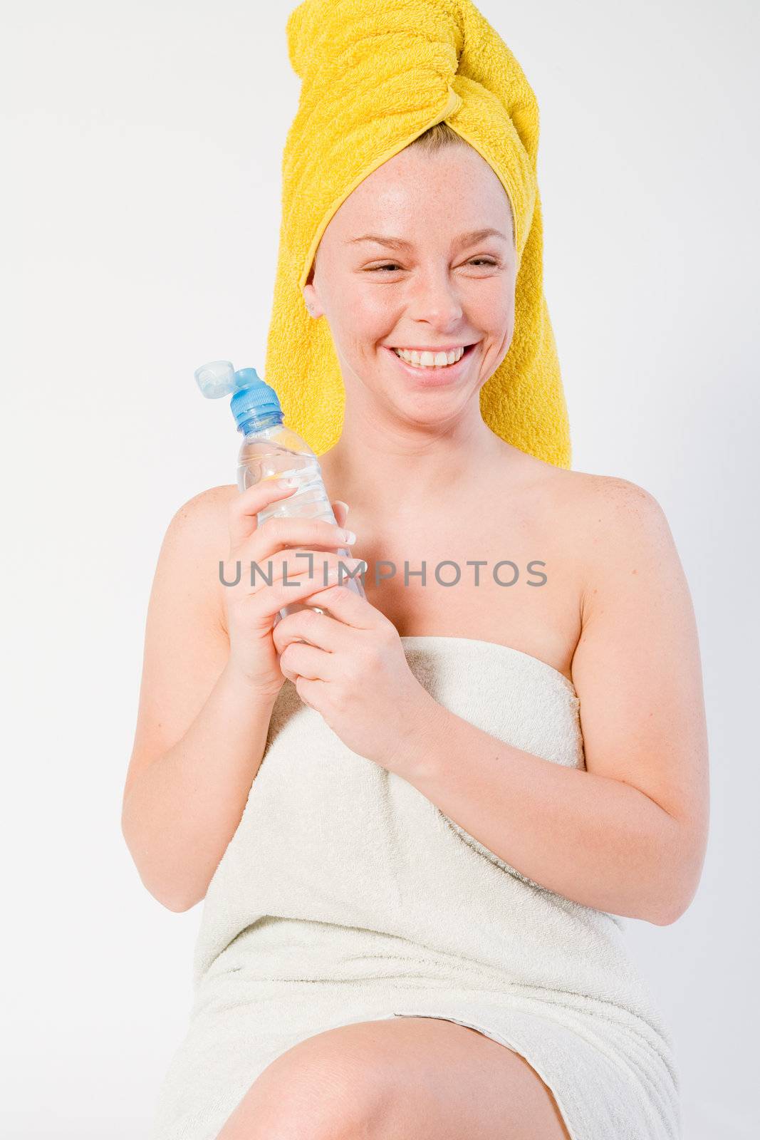 Studio portrait of a spa girl smiling with a bottle