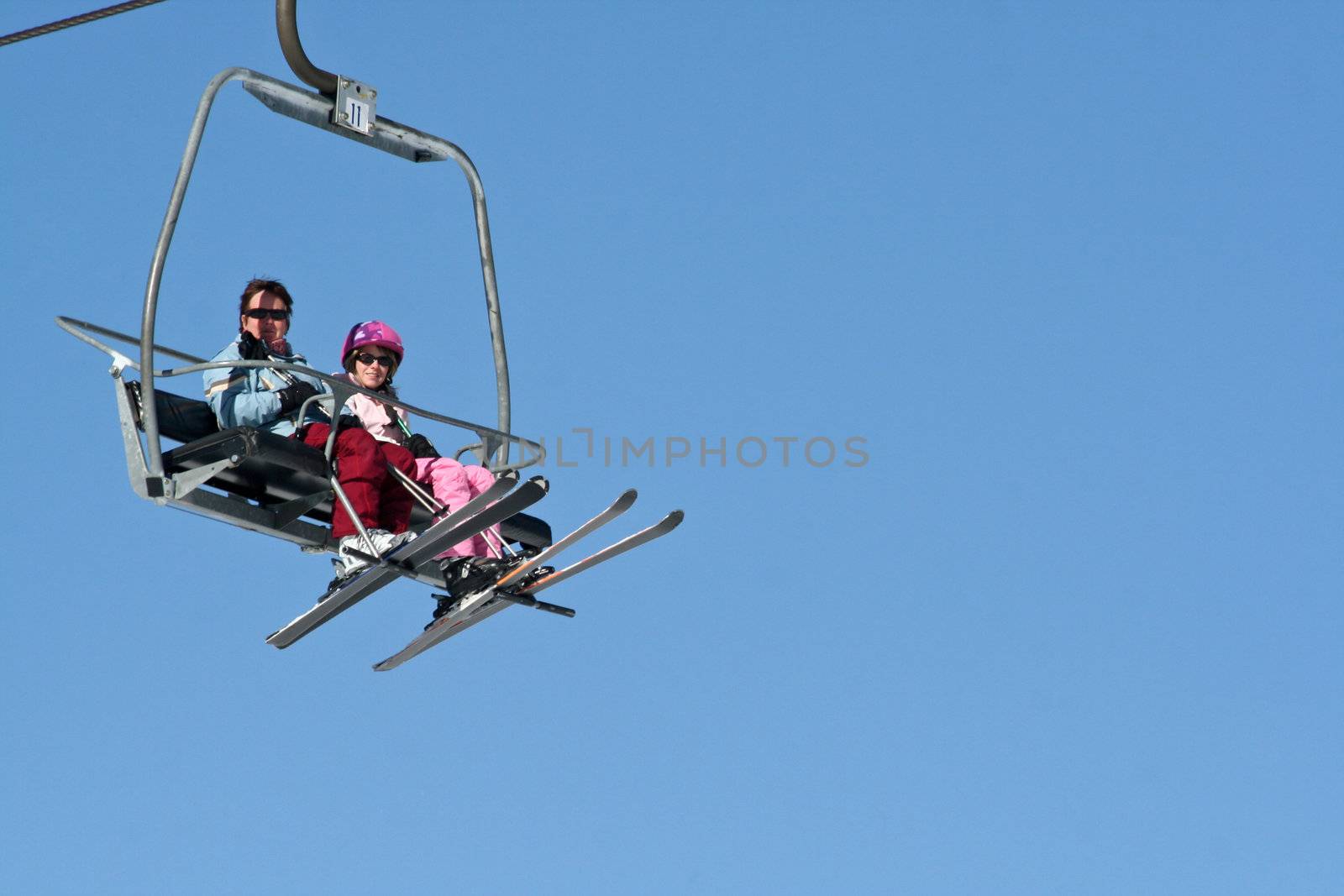 Two women riding the Ski lift. by groomee