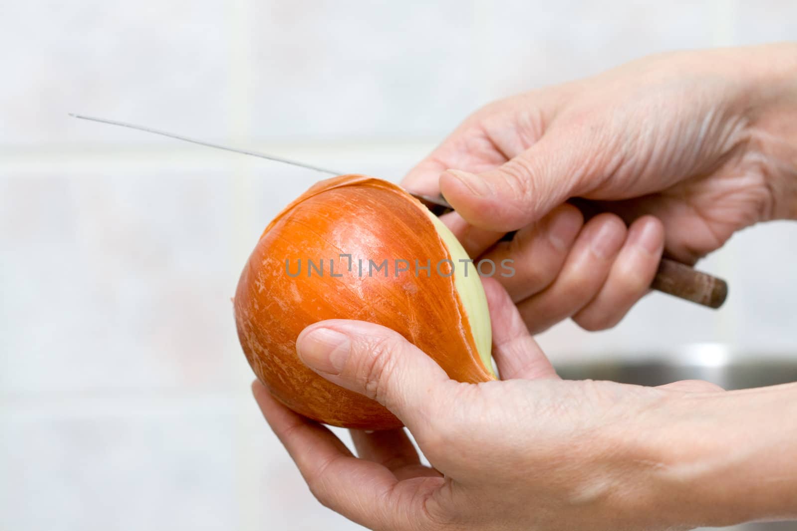 onion and knife in woman's hands