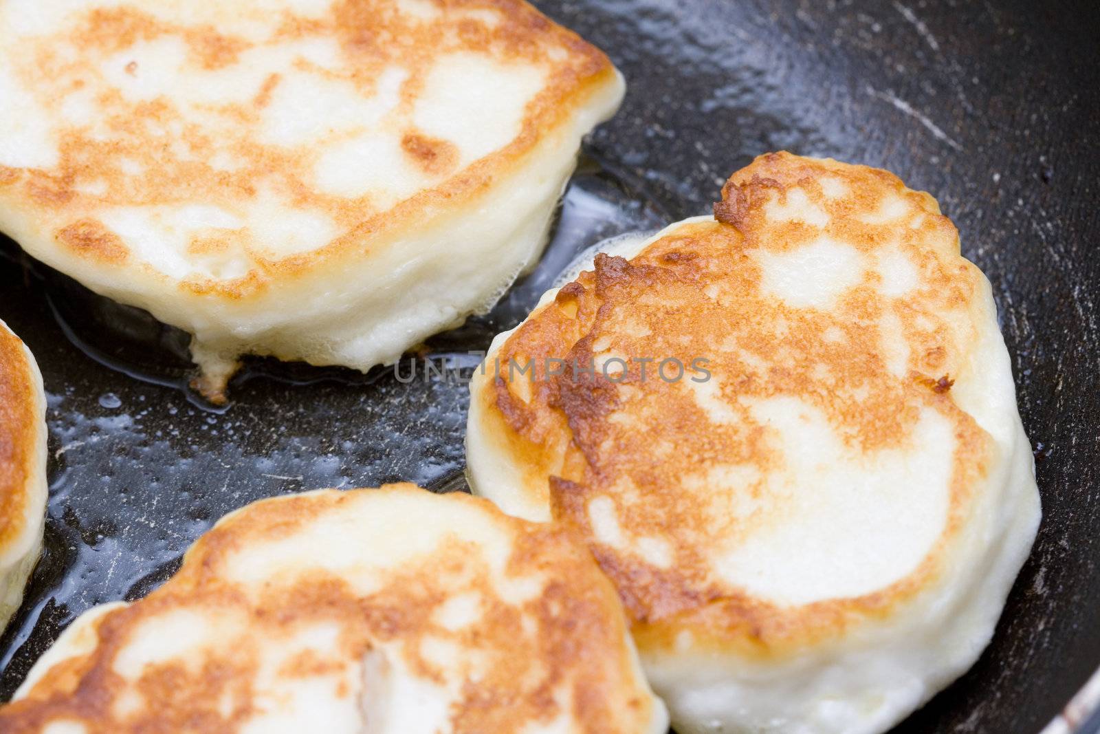 cooking fresh cheese cakes in the frying pan