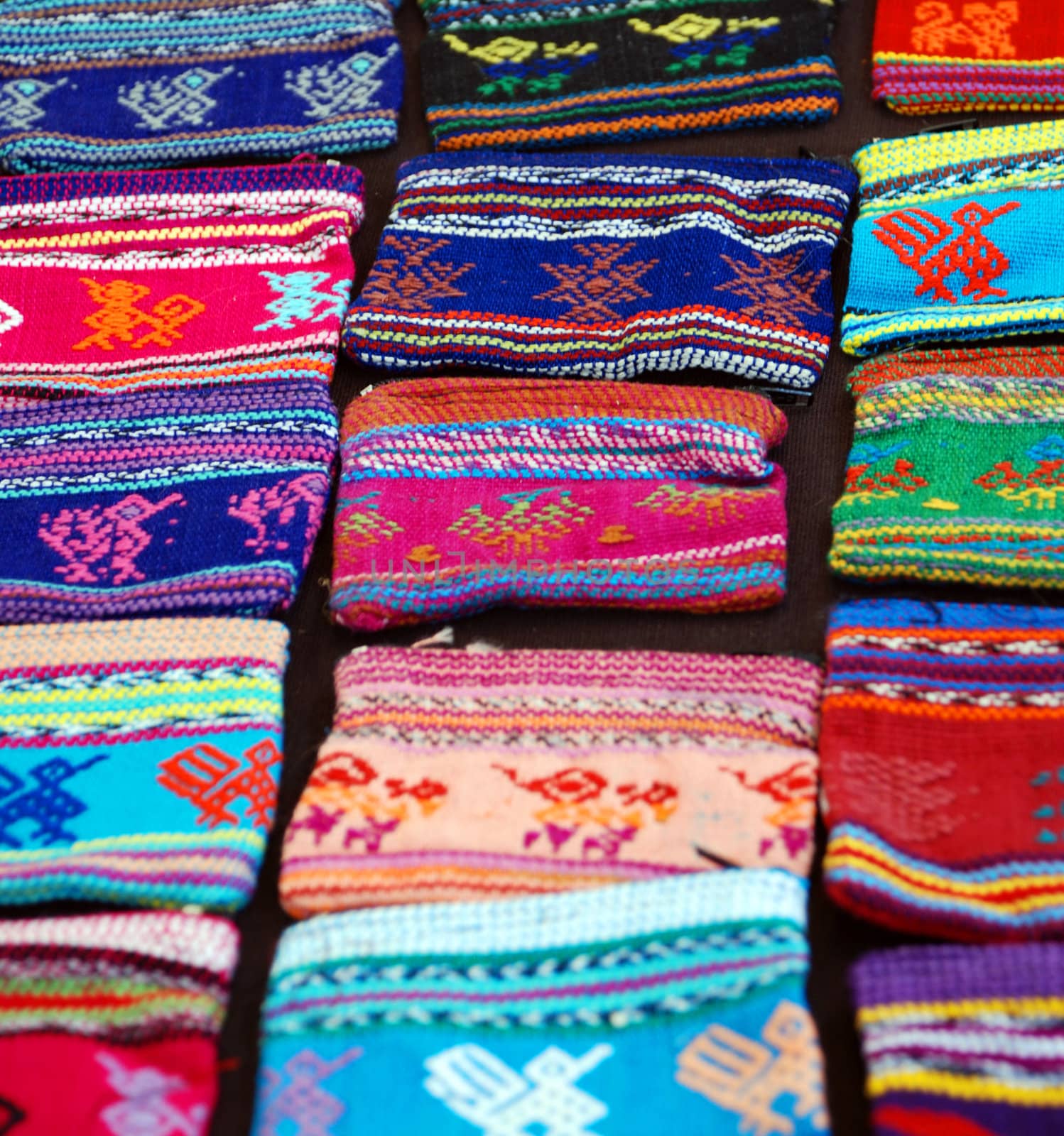 A display of woven purses at an outdoor market 