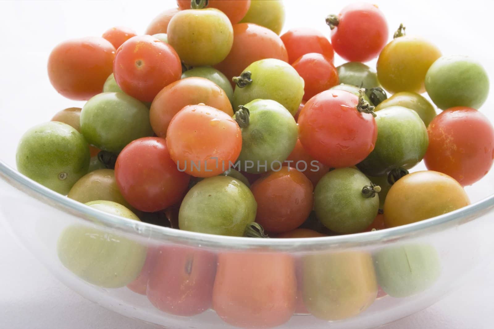 Cherry tomatoes fresh from the vine, in a glass bowl.  