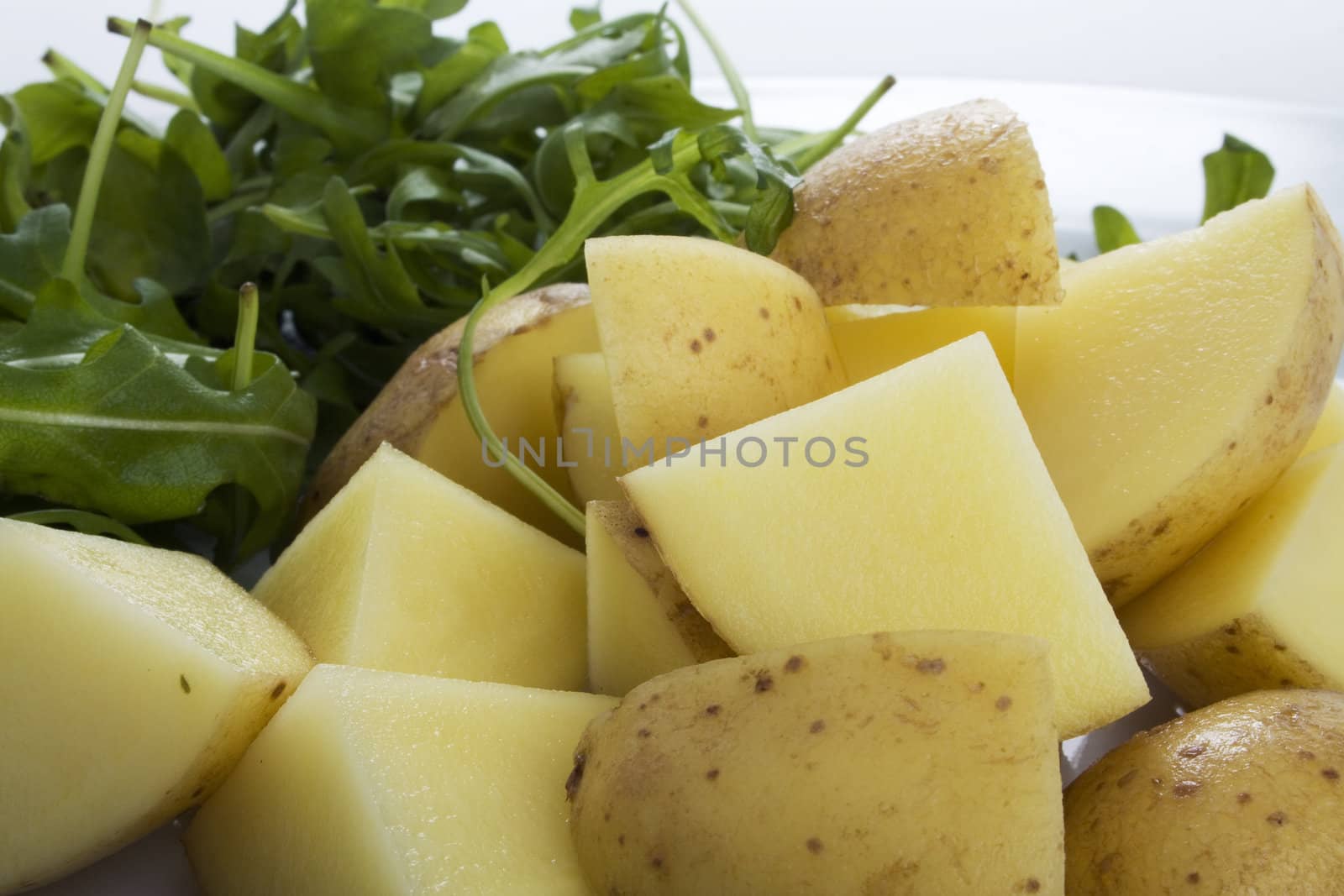 Raw cut potatoes and rocket lettuce (rucola), ingredients for a gourmet potato salad.  