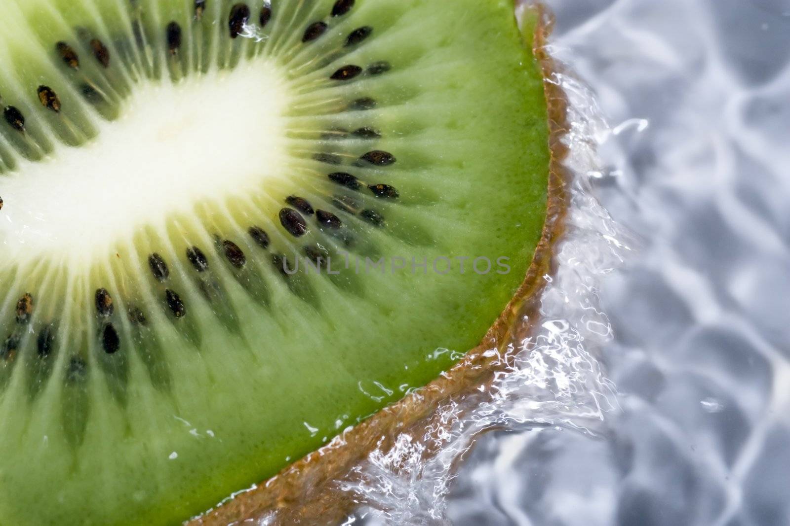 Kiwi under running water, with water running over sides.