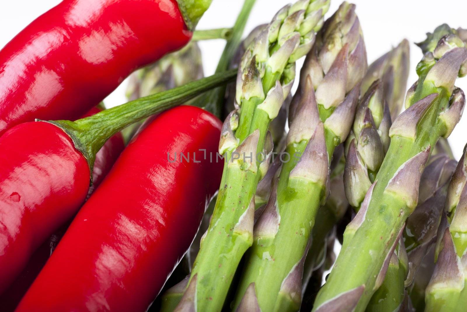 Closeup of raw red chili peppers and asparagus.