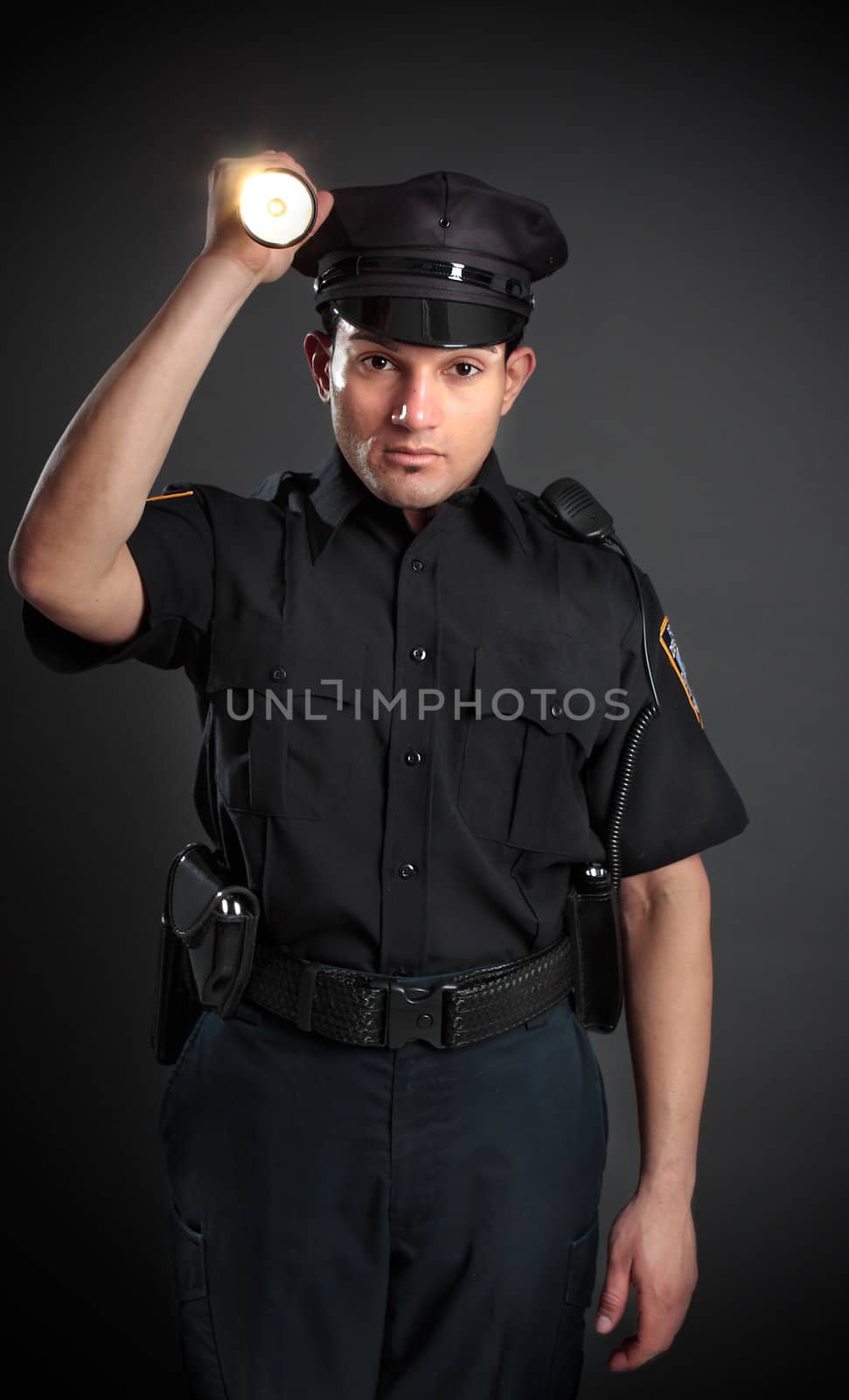 A policeman, night patrolman or security guard shining a flashlight torch to investigate or search.