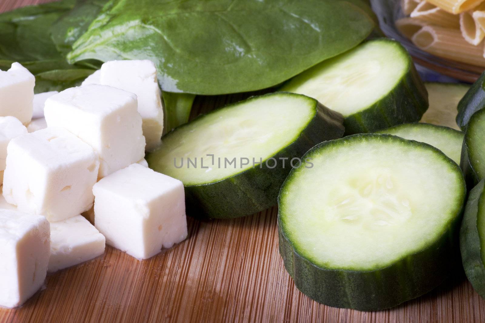 Feta cheese, cucumber, spinach and penne pasta ready for a pasta salad