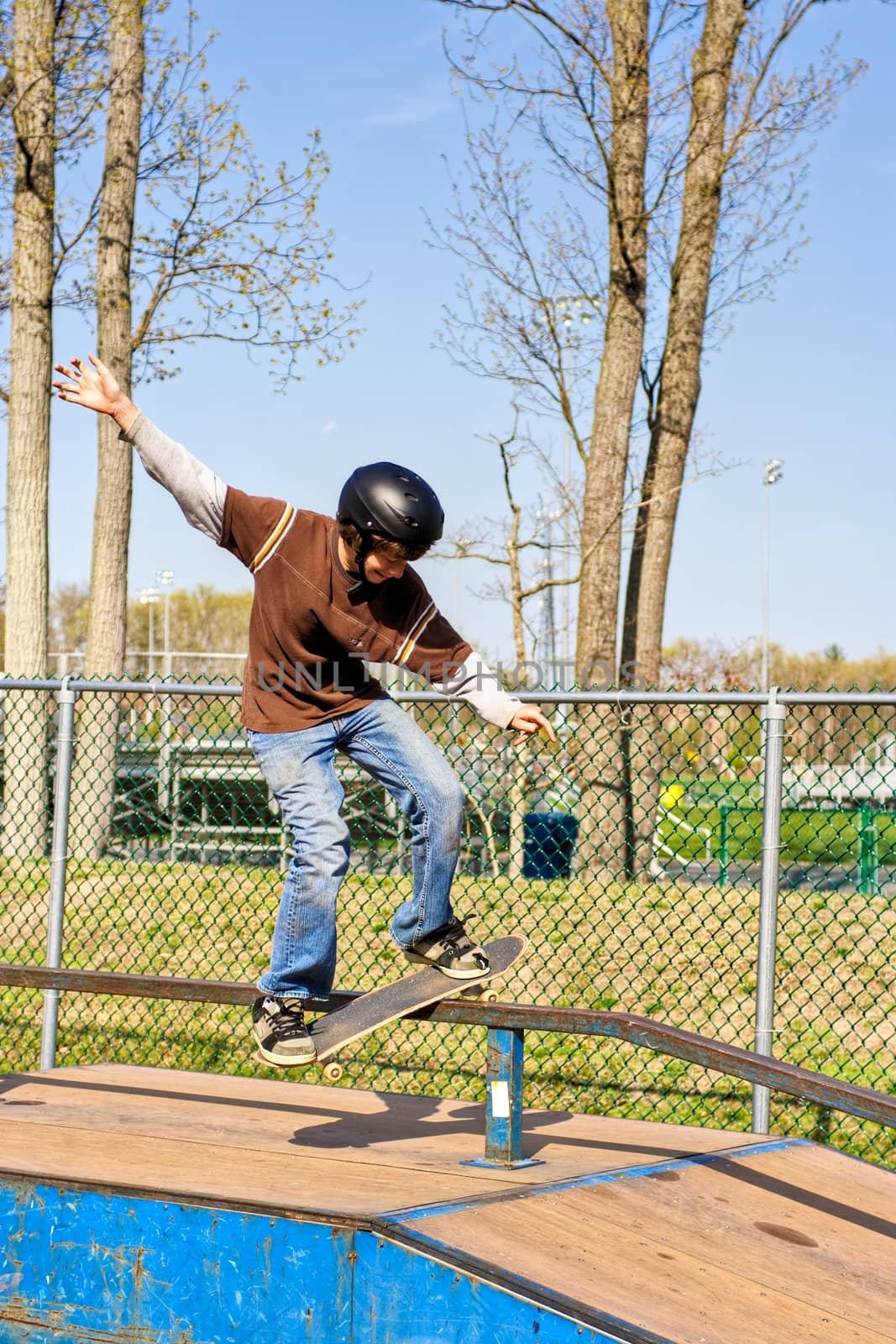 A teenage boy skateboarding at a park