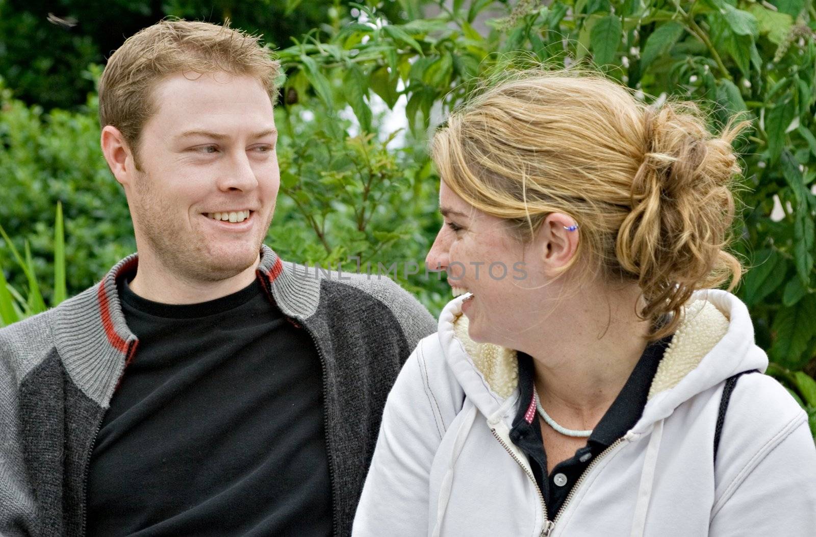 A young man and young woman talking and laughing. They are enjoying each others company.