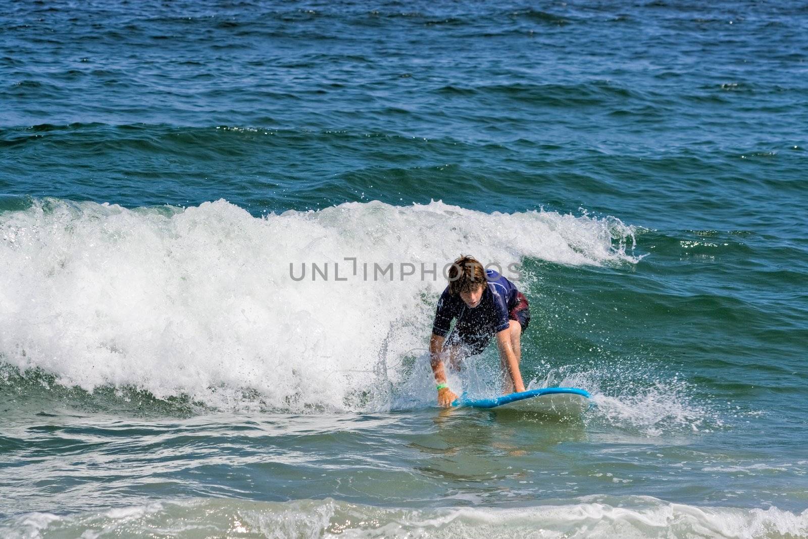 A teenage boy surfing in the ocean
