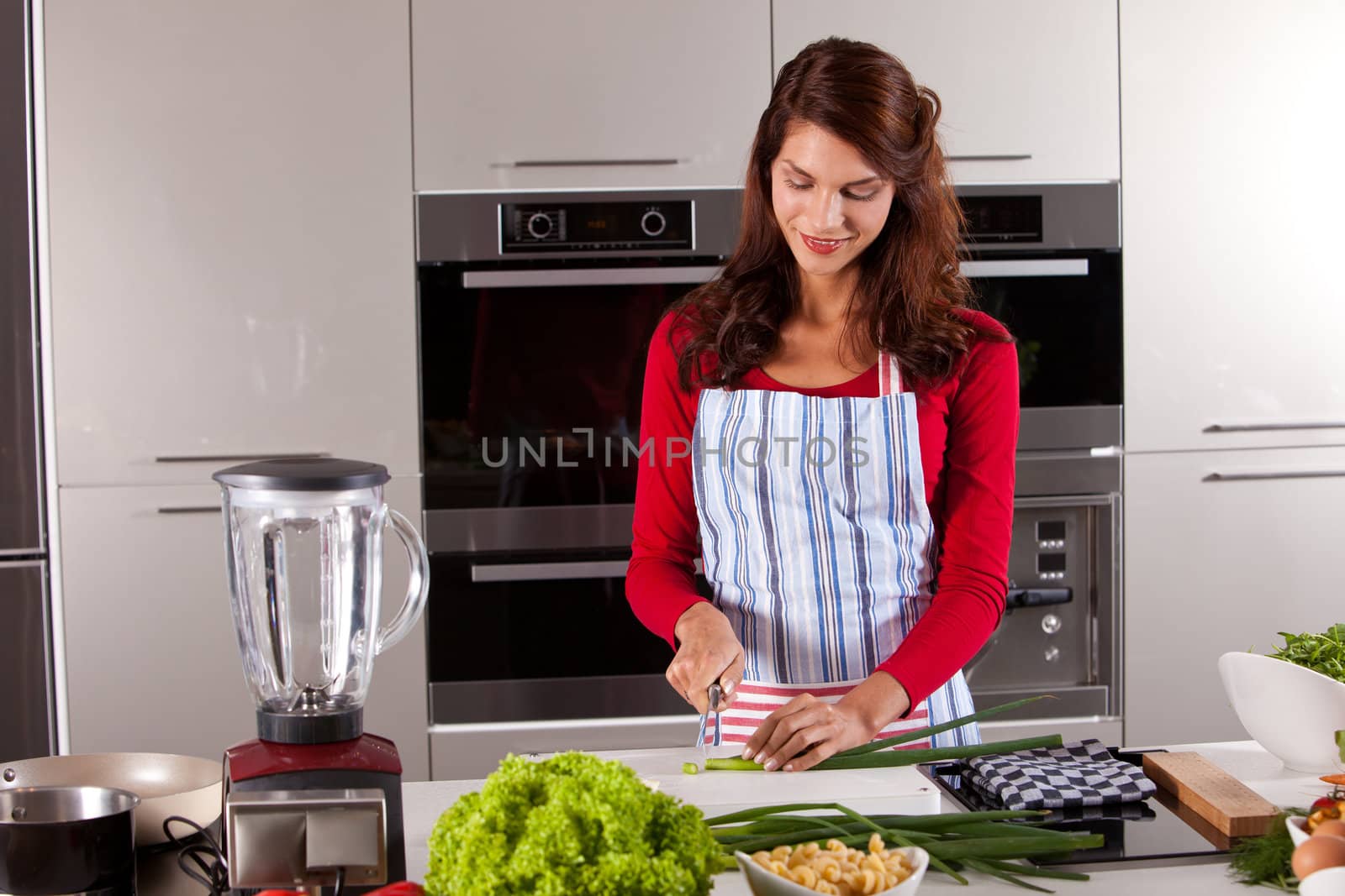 Beautiful woman preparing dinner for tonight by cutting the vegetables