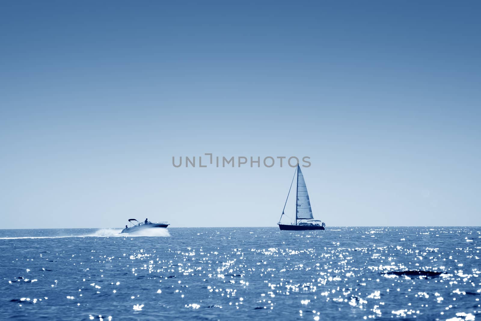A small boat facing a motor boat on open sea
