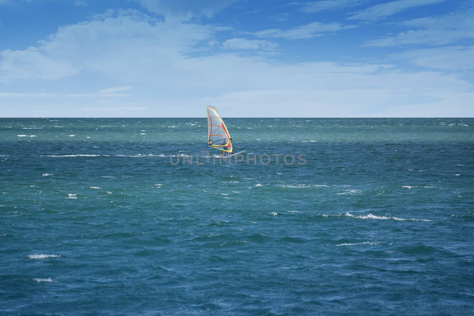 Windsurfer sailing on open sea on a windy day