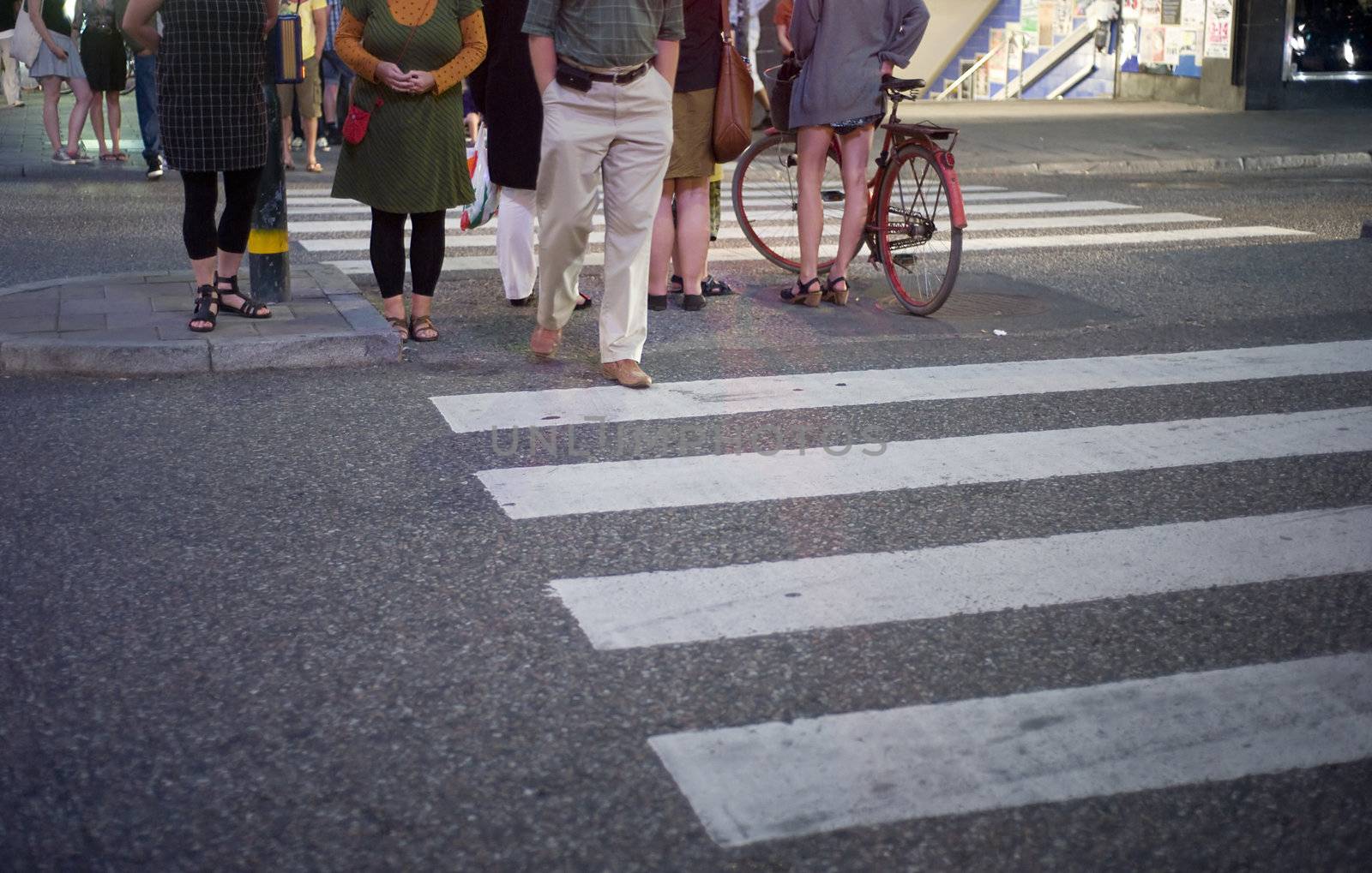 People standing on a crosswalk at night in Stockholm, Sweden