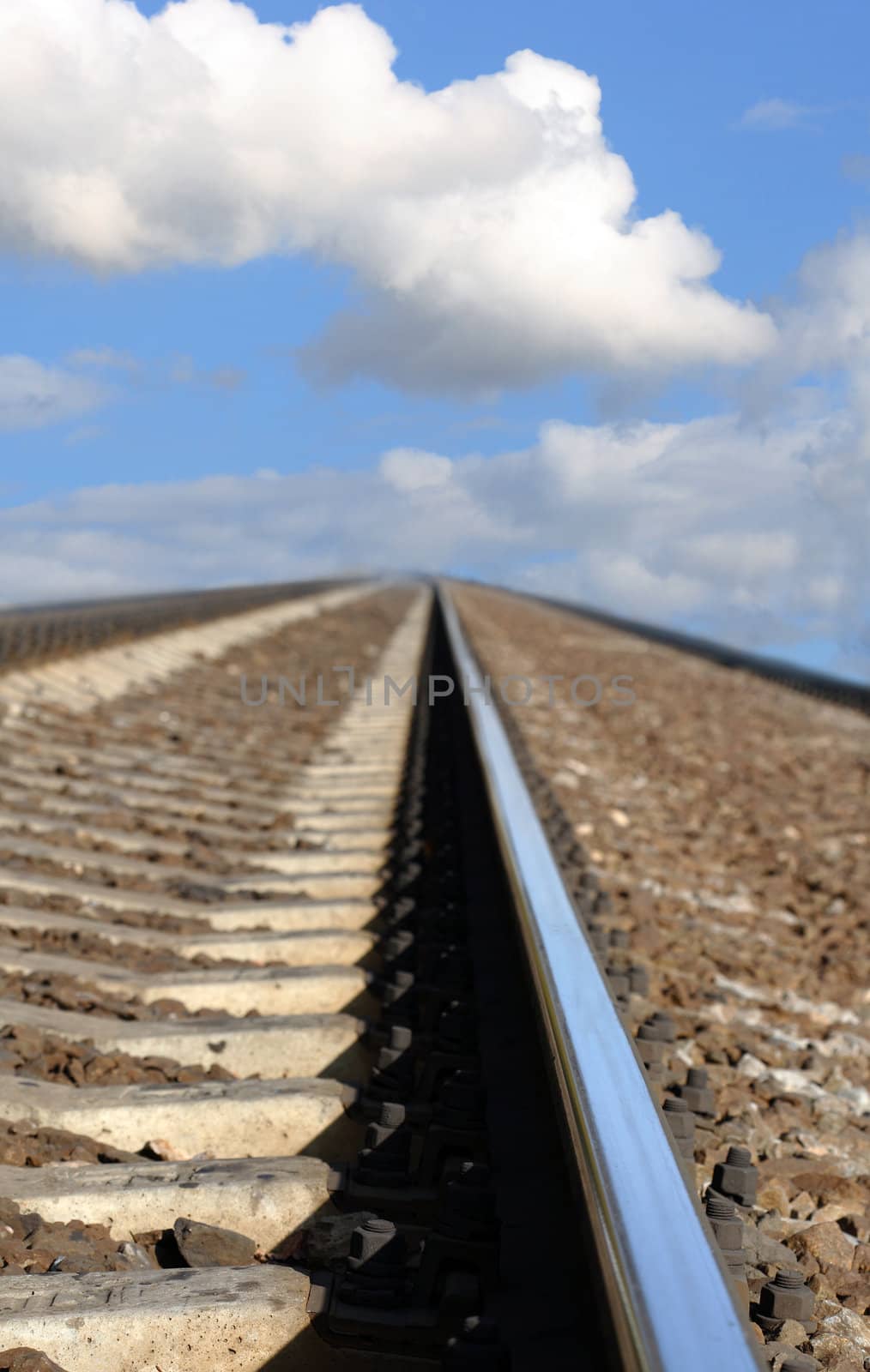 Closeup of railroad track on background with blue sky