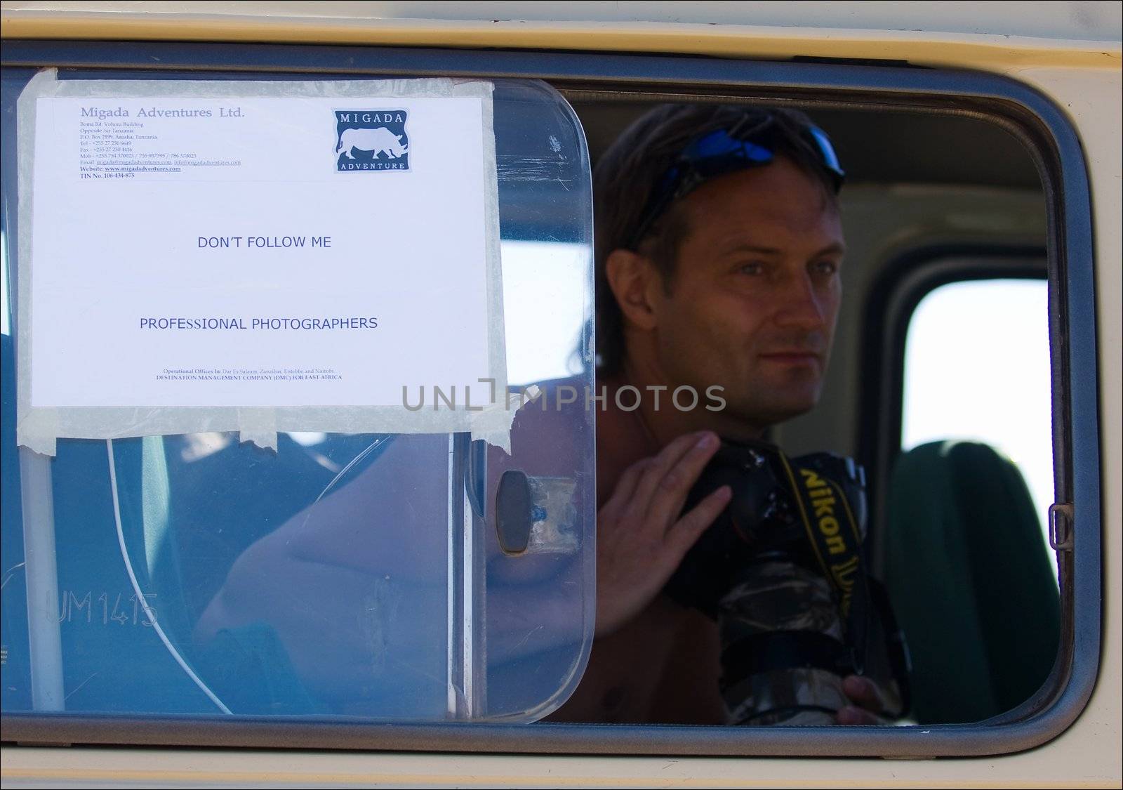 The wildanimal photographer in a window of the car for shooting on the wild nature.