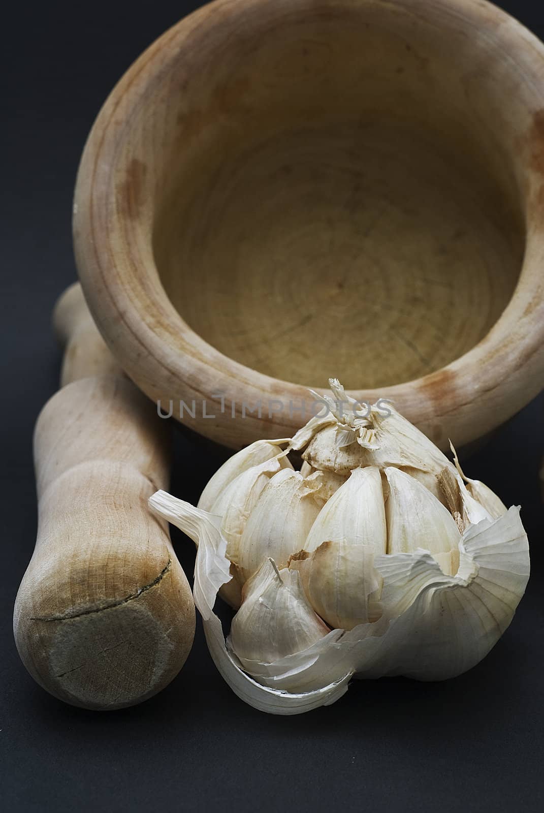 Garlic with mortar and pestle isolated on a black background.