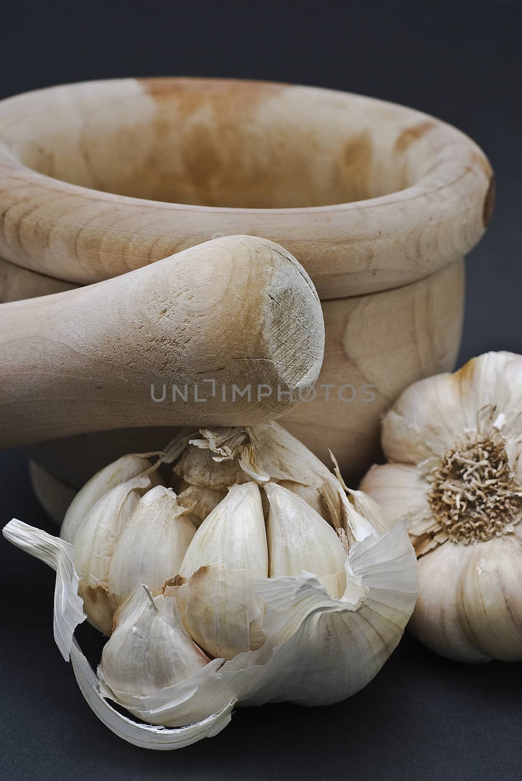 Garlic with mortar and pestle isolated on a black background.