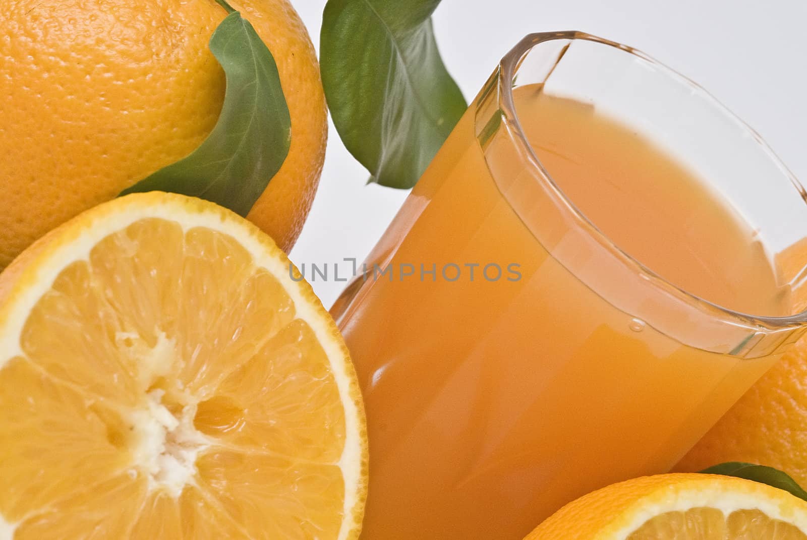 Spanish oranges from Valencia with leaves and its juice isolated on a white background.