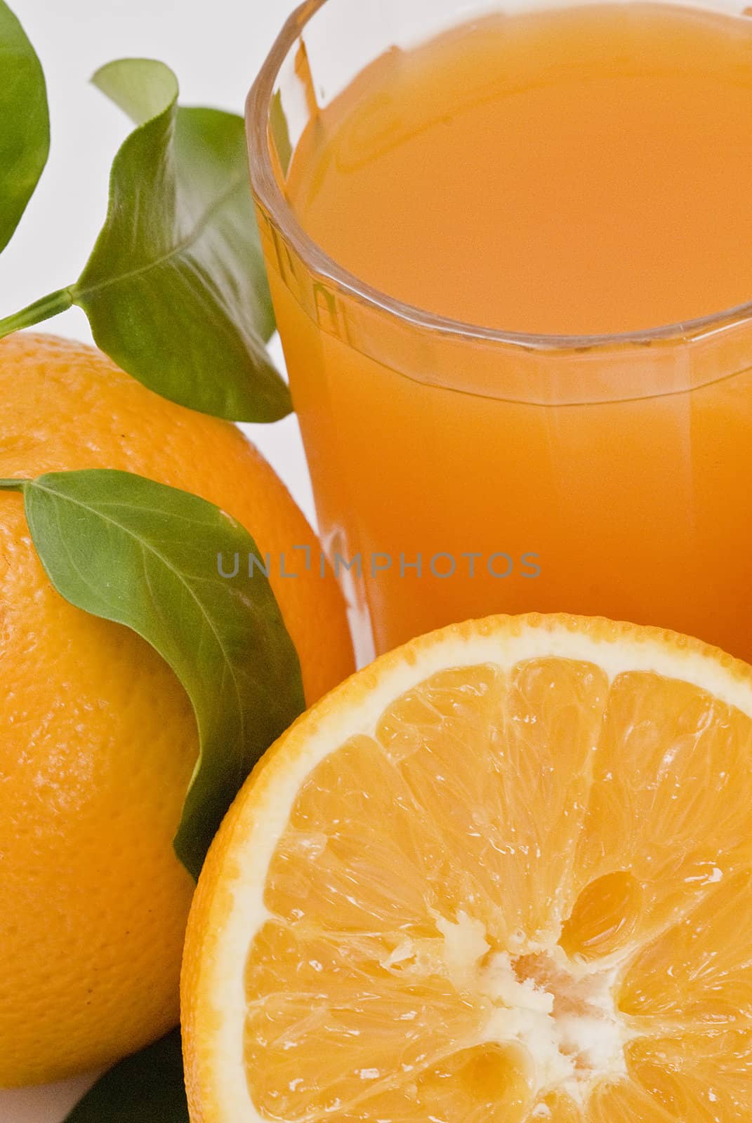 Spanish oranges from Valencia with leaves and its juice isolated on a white background.