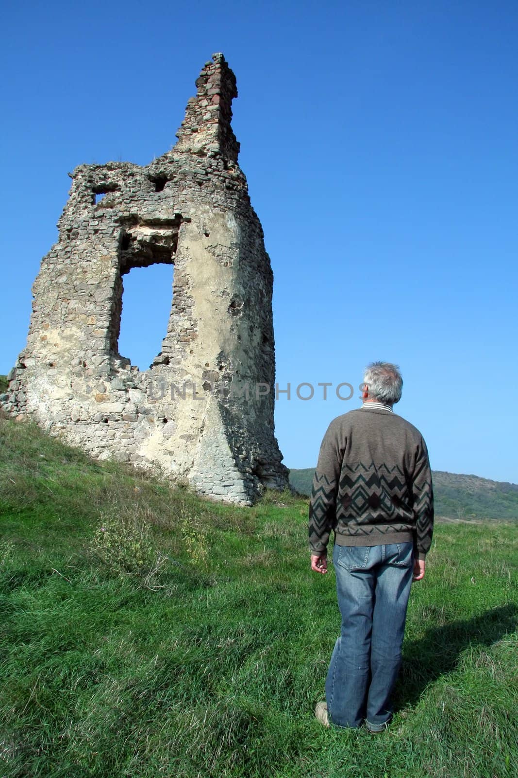 old man looking at old castle ruins, east Slovakia