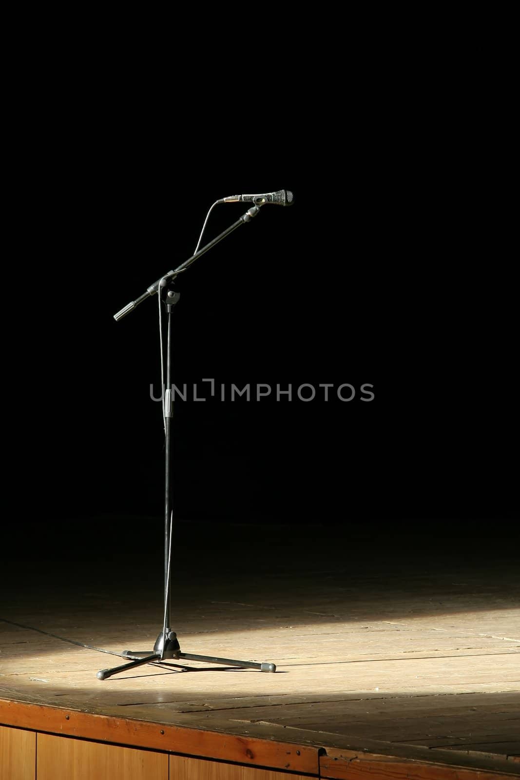microphone on wooden stage, black background
